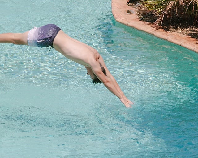 Man diving into pool at resort